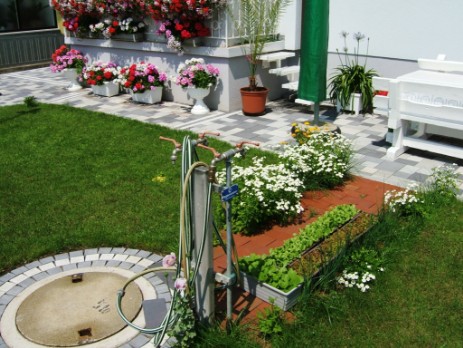 Regenwassersammelbehälter mit Regenwasserversorgung im Hausgarten